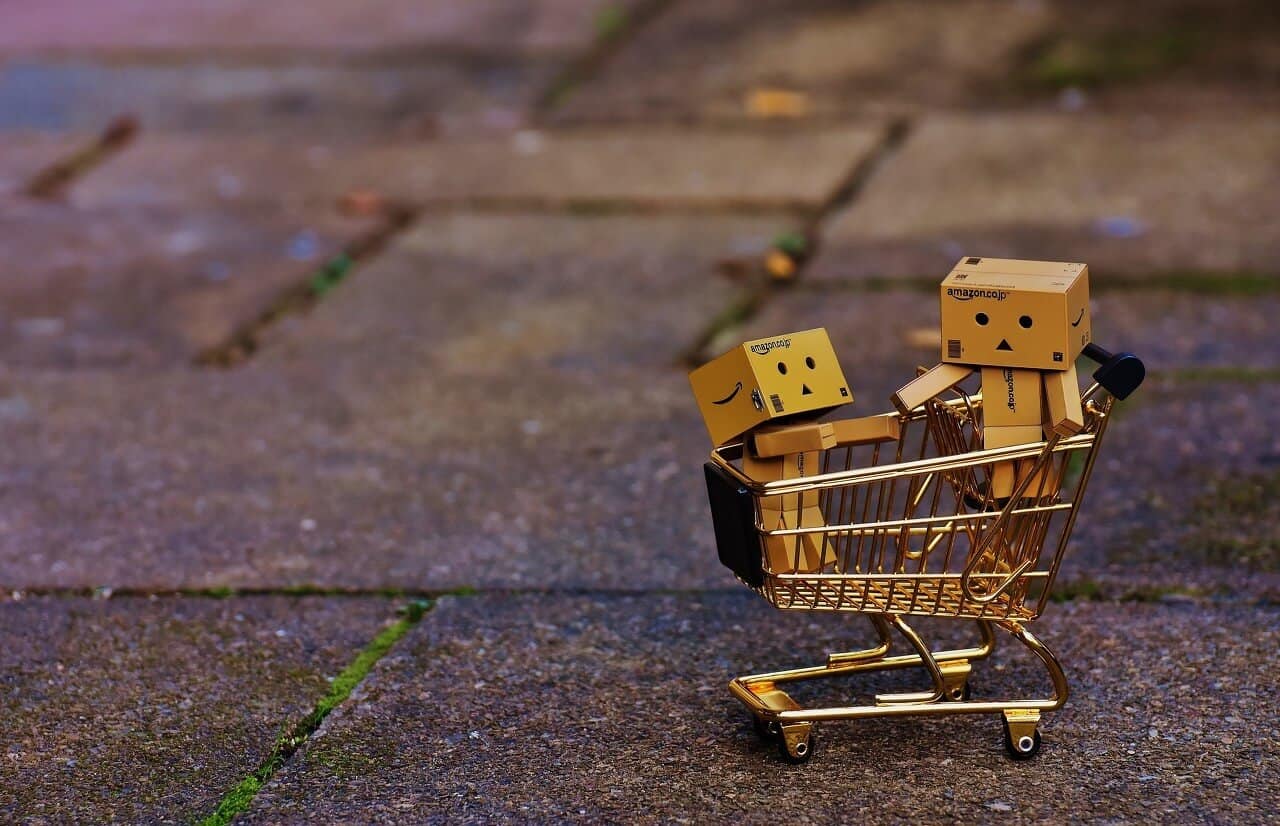 pupazzetti in legno in un minicarrello della spesa