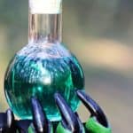 mano verde di strega che porge una pozione