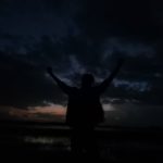 silouette di notte a braccia alzate