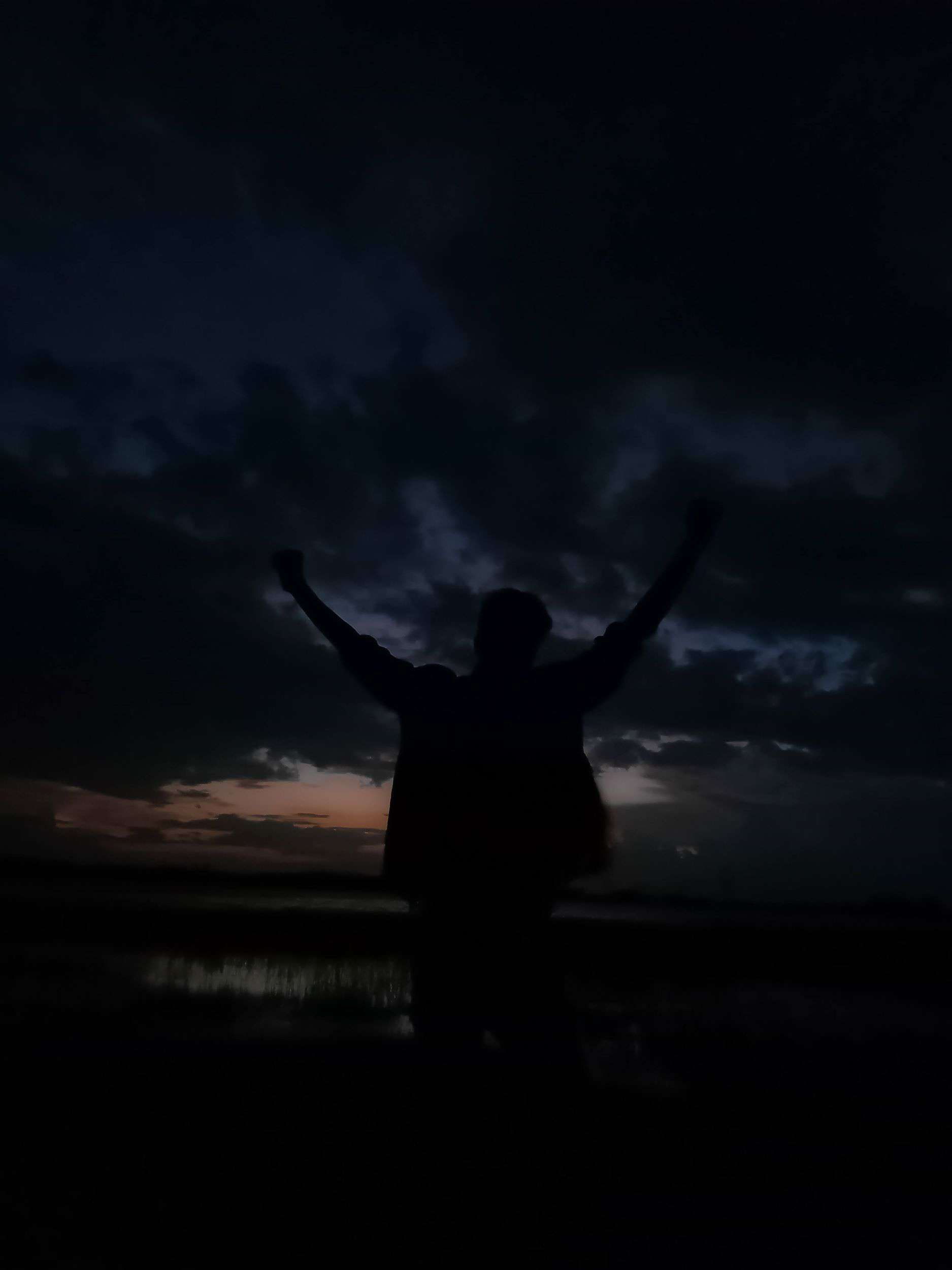 silouette di notte a braccia alzate